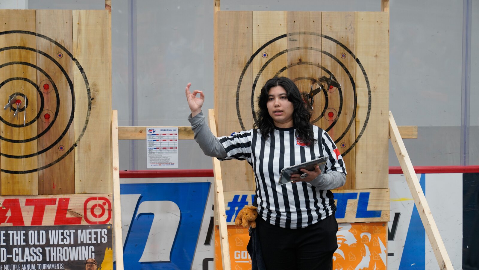 A WKTL judge officiating in front of the target boards at an event