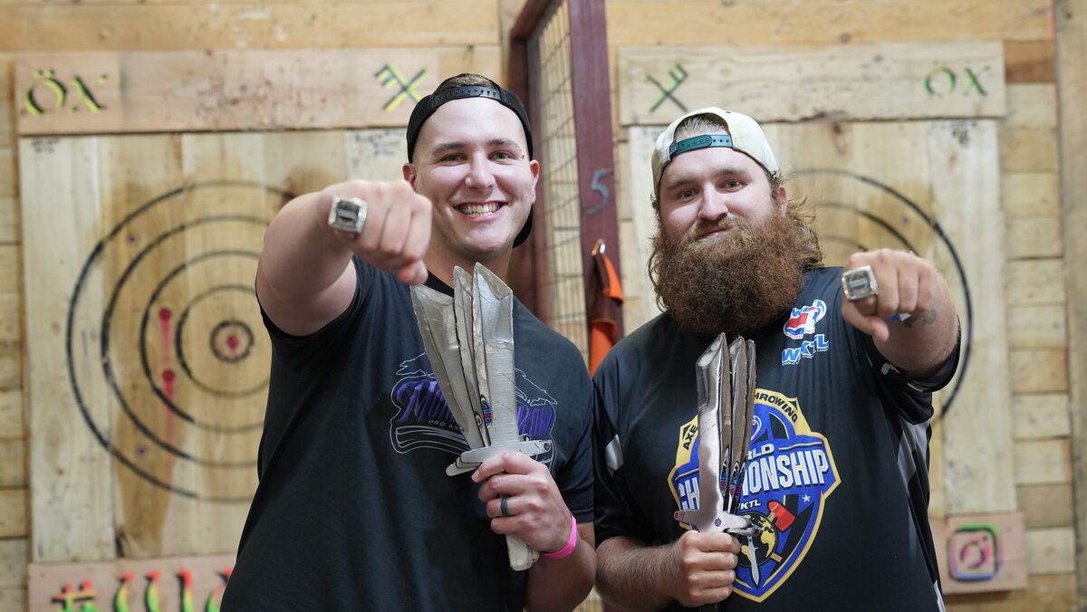 Two WKTL throwers holding knives and showing their championship rings